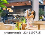 Small photo of Asian woman playing with her chihuahua dog in cafe at pets friendly shopping mall. Domestic dog and owner have fun outdoor lifestyle travel city on summer holiday vacation. Pet Humanization concept.
