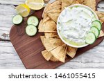 Traditional Greek Tzatziki dip sauce made with cucumber sour cream, Greek yogurt, lemon juice, olive oil and a fresh sprig of dill weed. Served with toasted Za'atar Pita bread.  Top view  or flat lay.