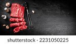 Pieces of raw beef on a stone board. On a black background. High quality photo