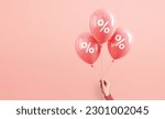 Small photo of Hand of woman holding pink balloons with percent on pink background, Minimal, Sale and discount. copy space.