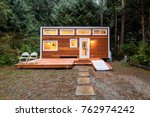 Small wooden cabin house in the evening. Exterior design.