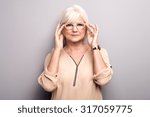 Portrait of cheerful senior woman wearing eyeglasses, looking at camera. Lady with grey hair. Studio shot.