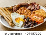 Full English Breakfast including sausages, grilled tomatoes and mushrooms, egg, bacon, baked beans and bread.