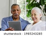 elderly couple using a tablet... | Shutterstock . vector #1985243285