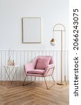 Small photo of Blank picture frame by a pink velvet armchair