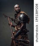 Small photo of African barbarian dressed in protective armor and deerskin wielding an axe