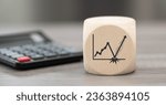Small photo of Wooden block with symbol of rebound concept and calculator on background