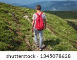 Small photo of Traveler man with a red backpack, guy lost in mountains walking along path, Boy spring summer walk back in nature, hiking in forest on top, trail, equipment for tourism and sports, afoot lifestyle