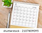 The July 2022 desk calendar with pen on wooden table.