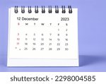 Small photo of December 2023 Monthly desk calendar for 2023 year on purple background.