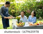 Small photo of Happy Asian Elderly couple enjoying time in they home garden after work life. Retired person taking care of health after retirement have good Meal salutary food Life insurance concept
