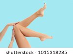 Beautiful long woman's legs with smooth skin after depilation on pastel blue background.