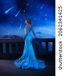 Small photo of Photo with noise. Fantasy woman princess stands on balcony looks at night sky space cosmos falling stars. Girl enjoy magic starfall ball. Elegant long shiny blue evening dress . Fairy lady Queen.