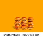 Small photo of Sliders with cheese (mini hamburgers). Nine sliders on wall with solid yellow background. Plain hamburger bun