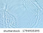 Small photo of Blurred transparent blue colored clear calm water surface texture with splashes and bubbles. Trendy abstract nature background. Water waves in sunlight.