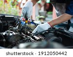 A mechanic is repairing a car about the engine's valve system.