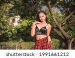 Small photo of A young and confident young Filipina in a black spaghetti strap top exposing her midriff. Weekend stroll outdoors.