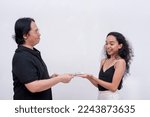 Small photo of A dad smirks while handing over a generous allowance to her giddy daughter. Isolated on a white background.