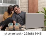 Small photo of An asian couple squeals and cringes in disgust while watching a gory horror movie on their laptop at the living room.