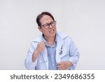 Small photo of A doctor cringes realizing he made a mistake to his chagrin. Of asian descent, middle aged male in his 40s. Isolated on a white background.