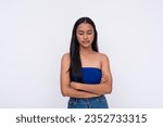 Small photo of A young Filipino woman looking down, slightly disappointed. Expectations let down. Isolated on a white background.