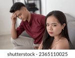 Small photo of A young moody woman is dissatisfied with her current boyfriend, looking regretful. A hurt wife distrusting her husband. Potential breakup scenario.
