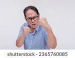 Small photo of A middle aged asian man threatens to hit someone with his fist if they come closer. A hotheaded dad putting his guard stance up. Isolated on a white backdrop.