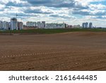 Small photo of Agricultural field near major cities. Poor conditions for conducting agribusiness and growing crops in an unfavorable place. Environmental pollution.