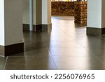 Small photo of The detail of the corner baseboard on the wall and granite tiles on the floor. A white wall with a copy space, decorated with decorative bricks and baseboards. Interior design in a office building.