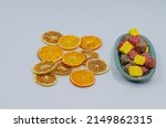 Turkish delight. Colorful marshmallows in porcelain plate isolated on white background. Dried orange and lemon slices. selective focus. noise effect.
