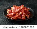 Fried crunchy Streaky Bacon pieces in a black plate