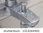 Close-up of shower mixer faucet with limescale, white chalky deposit and stains. Formed on the plumbing system by a combination of soap residues and hard water. Concept of cleaning limescale plumbing