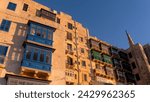 Small photo of Residential house facade with traditional Maltese navy blue enclosed wooden balconies in Valletta, Malta, in summer day. Authentic Maltese urban scene