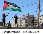 Small photo of Palestinians wave their national flags during a rally marking the 74h anniversary of what the Palestinians call the "Nakba," or "catastrophe", in front of UNESCO offices, in Gaza Strip on May 15, 2022