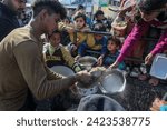 Small photo of A charity organization distributes food, “Takiya,” to displaced Palestinians, in the Gaza Strip. In Gaza, UNRWA said that the situation is becoming more disastrous, on February 9, 2024.