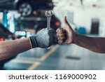 Close-up Thumb Up and Mechanics Hand with Tool. Automobile Master Wearing Gloves Showing Positive Gesture after Finishing Work. Technic occupation. Automobile Repair Service Concept.