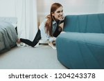 Small photo of Young Woman Moves The Sofa In The New Apartment. Reshuffle In The Room Concept. Domestic Problems. Clean Residence. Powerful Girl. Try Hard. Power Girl. Changes In The Living Room.