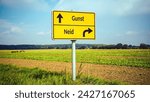 Small photo of An image with a signpost pointing in two different directions in German. One direction points to favour, the other points to envy.