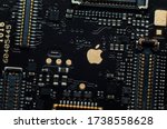 Small photo of Kiev, Ukraine - May 6, 2020: Image of a golden apple on the iphone se phone motherboard. Detached loopback connectors. Close-up, macro shot.