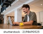 One adult modern man caucasian male with beard and mustaches wear causal shirt working remote from cafe freelance work or blog checking online content or browsing internet while sitting alone