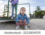 Small photo of One girl small caucasian child female toddler 18 months old in park in day by speedy spinner merry-go-round turnabout childhood and growing up concept copy space