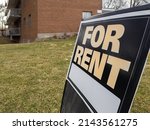 Small photo of Old weathered sign for rent in front of a residential low rise building. Investment property, affordable housing, real estate crisis concept.