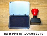 Small photo of stamp with red handle and stamp pad