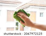 Small photo of woman hand hold green microfiber cloth or rag to clean window by wipe on glass cleaner bubble , housewordk concept