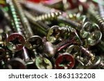 Macro close up of isolated pile metal crosshead screws in tool box (focus on left part of head in center)