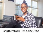 Small photo of Portrait of the beautiful Young woman Using Smartphone, Browsing in Internet, Checking Social Networks, Scrolling Newsfeed while Sitting At Home.