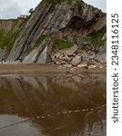 Small photo of Cliffs at Itzurun beach, nice reflexion on water