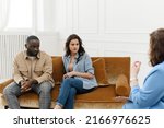Small photo of Diverse couple talking to psychologist woman about relationship problems. Marital Therapy. Family Reconciliation.