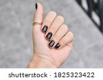 Black Manicured Nails. Nice Hand with Golden Jewelry 