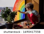 let's all be well. child at home draws a rainbow on the window. Flash mob society community on self-isolation quarantine pandemic coronavirus. Children create artist paints creativity vacation